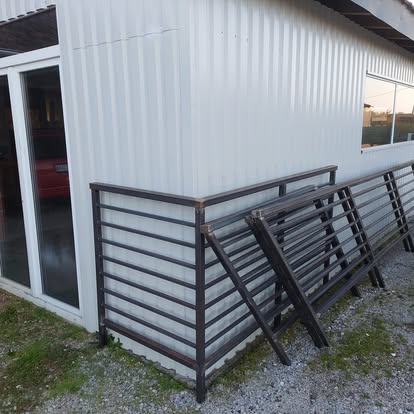 Tamna metalna ograda s horizontalnim šipkama uz vanjski zid objekta — Knight Project Zagreb